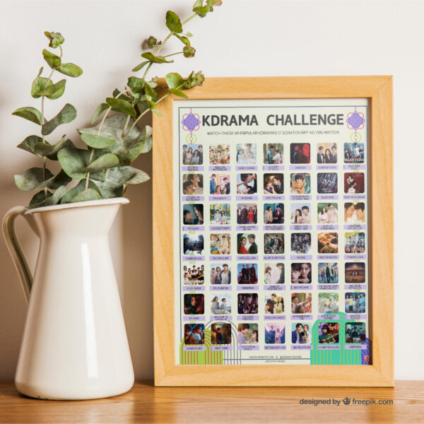A vibrant poster on a tabletop titled "KDRAMA CHALLENGE" displays 49 Most Popular Kdramas within a wooden frame. The poster features a grid of images and drama titles. On the table, there is a houseplant to the left of the frame.